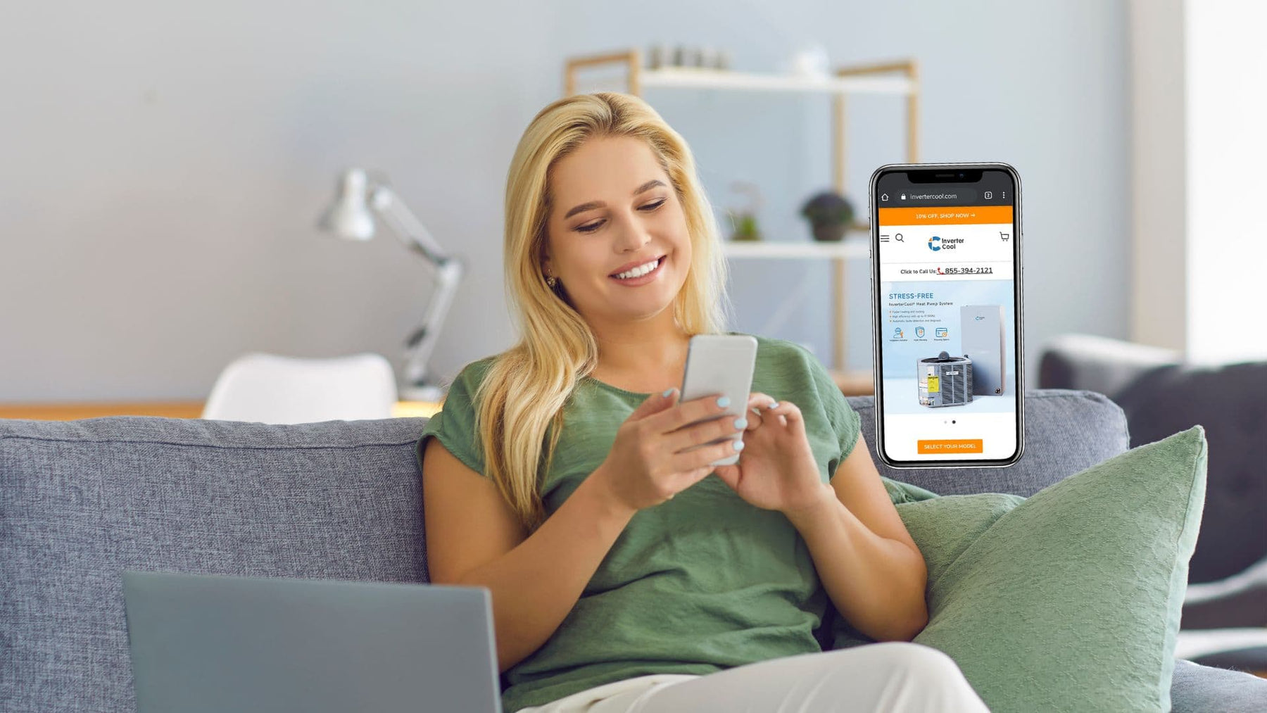 A woman sitting on a sofa buys an A/C system on InverterCool website on her mobile phone.
